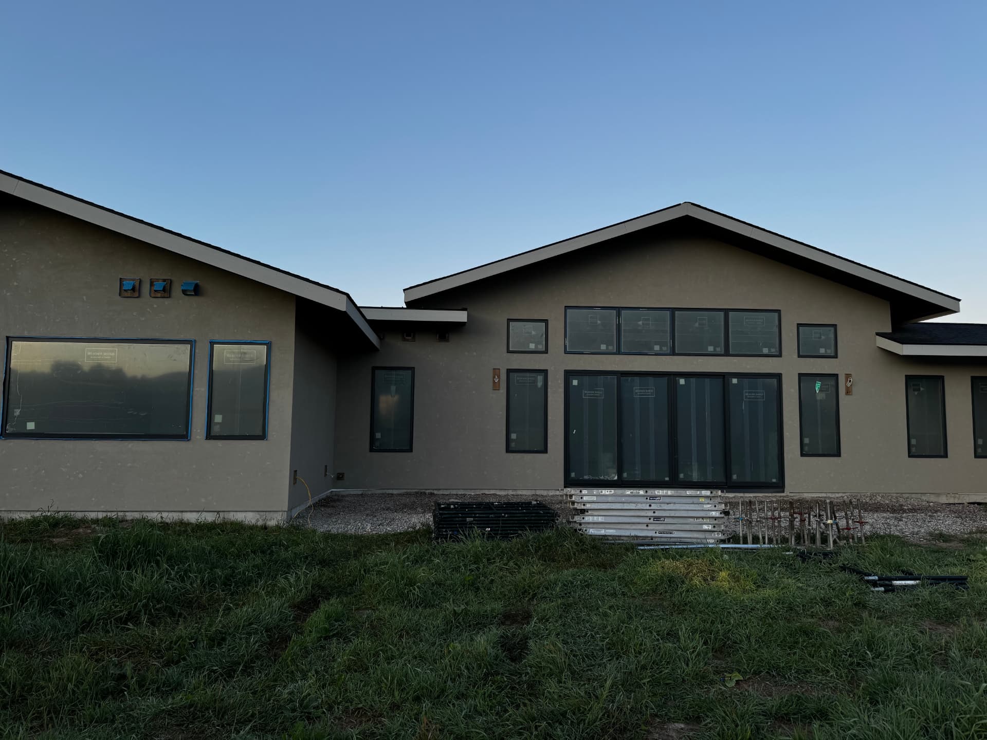 Warm tan stucco exterior on a newly built single-level home near Whitefish, Montana